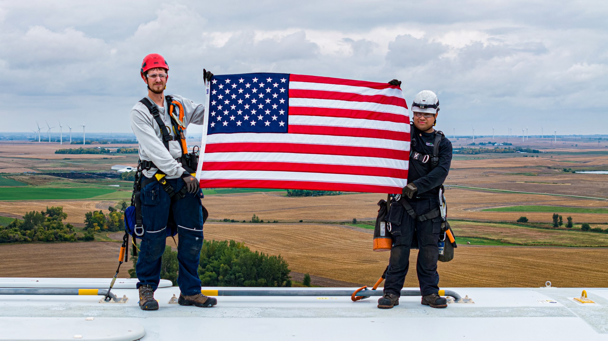 Drone picture of students in Tehachapi on top of a Turbine carrying the US Flag.